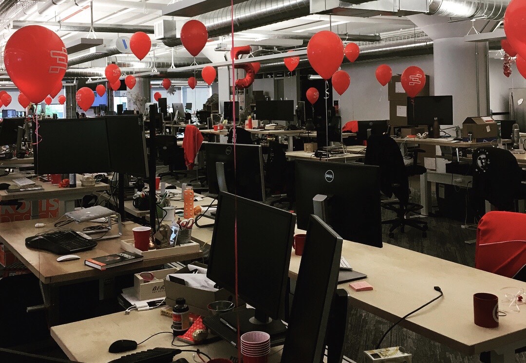 Red balloons with product icons filling the office — impossible to ignore on launch day