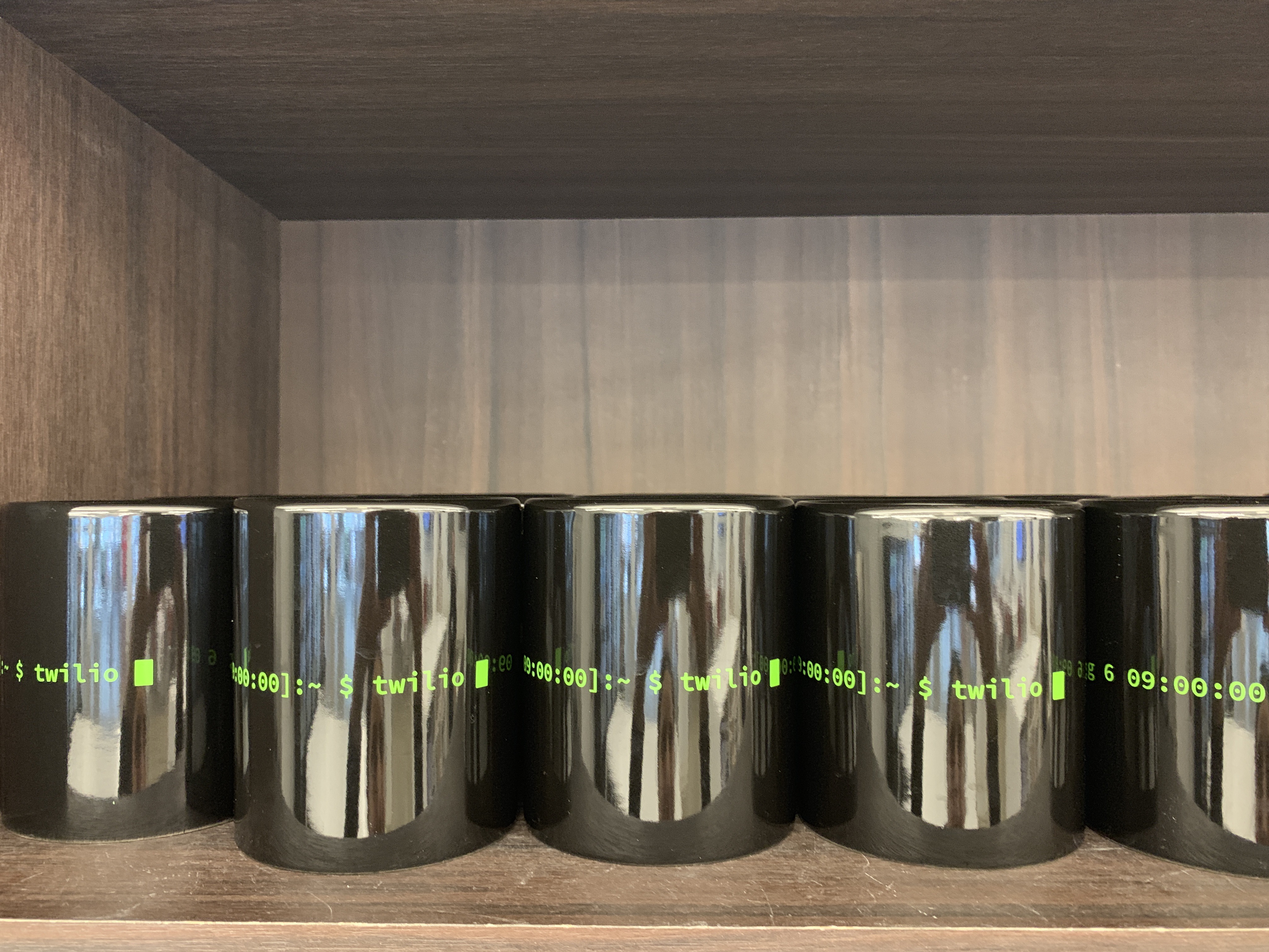 Black Twilio CLI mugs with green terminal text replacing the iconic red mugs in every office kitchen globally