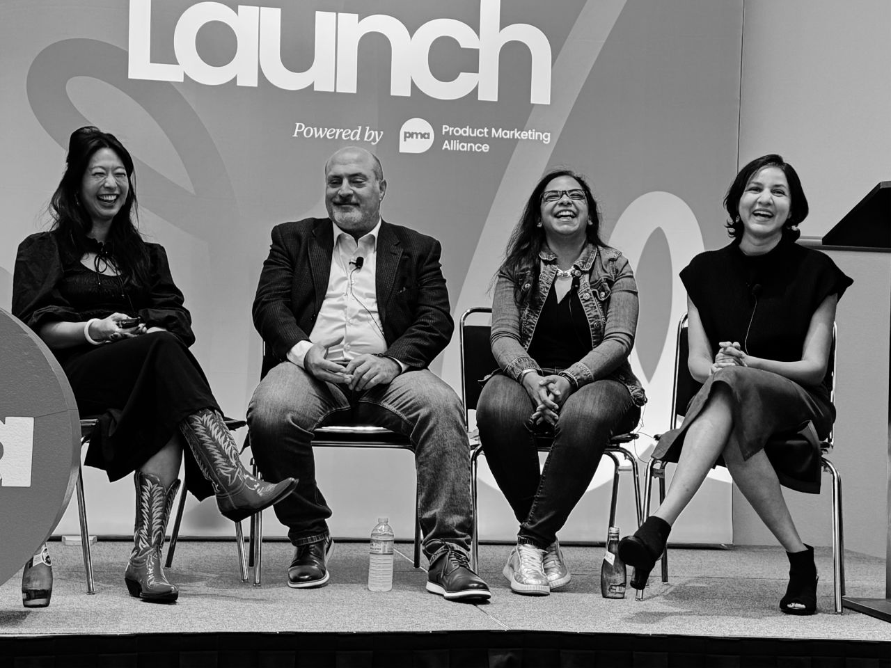 Panel discussion at PMA Launch conference — four speakers sharing a laugh on stage